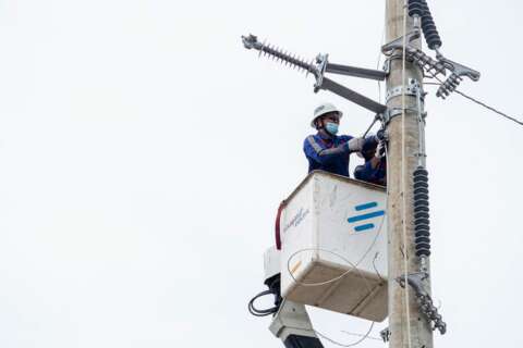 Visayan Electric linemen work on a damaged pole